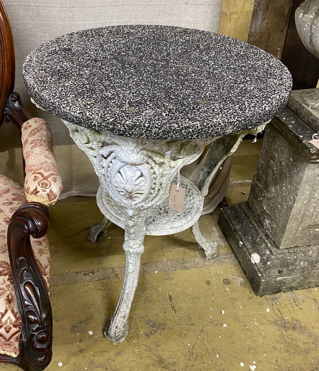 A Victorian cast iron circular garden table with weathered stone top, diameter 61cm, height 72cm